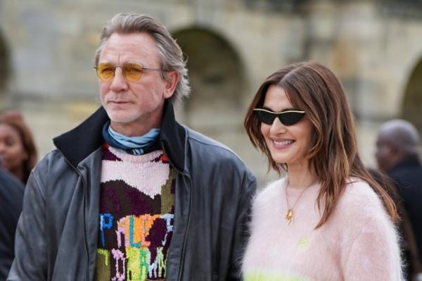 Daniel Craig and Rachel Weisz pose at the Loewe fashion show in September 2024, both wearing pink-hued jumpers